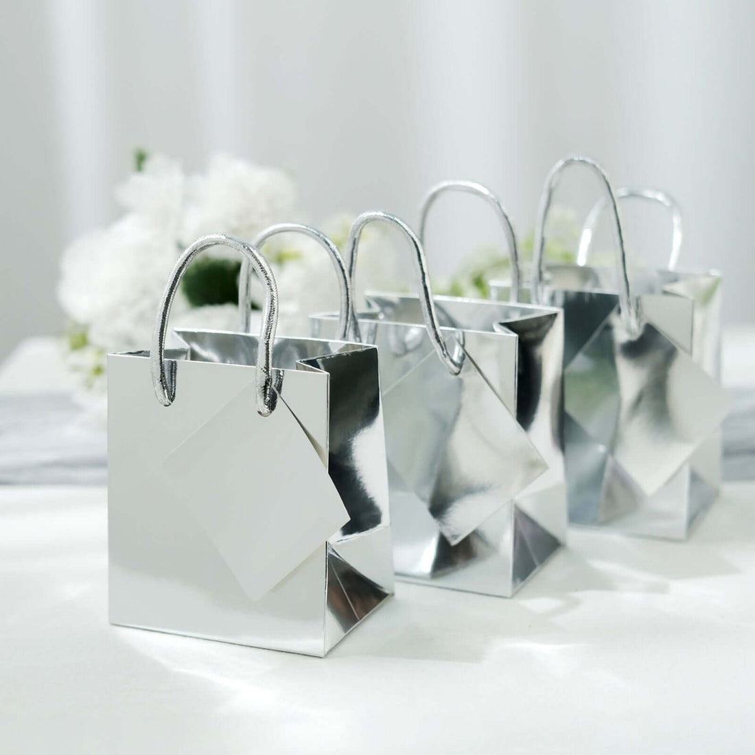 Silver gift bags with handles on a soft background.