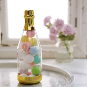 Colorful decorative balls in a clear bottle with a gold base.