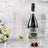 Chilled champagne bottle with glasses, ice cubes, and cherries on a textured background.