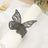 Black lace butterfly napkin ring on a white napkin.