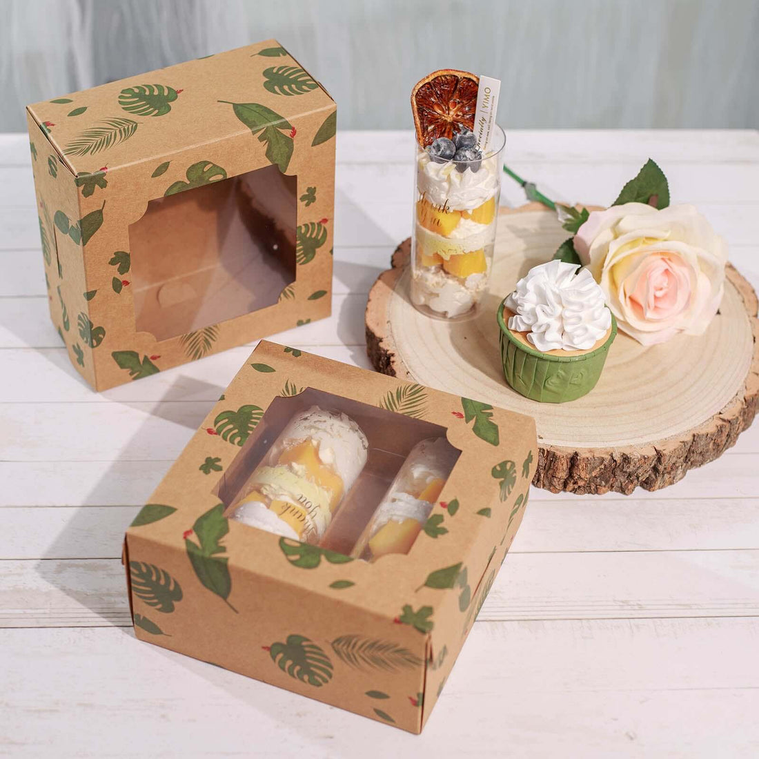 Decorative dessert packaging with tropical design and clear windows.