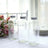 Three clear glass bottles with silver lids on a table.