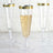 Elegant clear champagne flutes with gold rims, filled with bubbly drink.