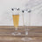 Elegant clear champagne flutes with silver rims on a wooden surface.