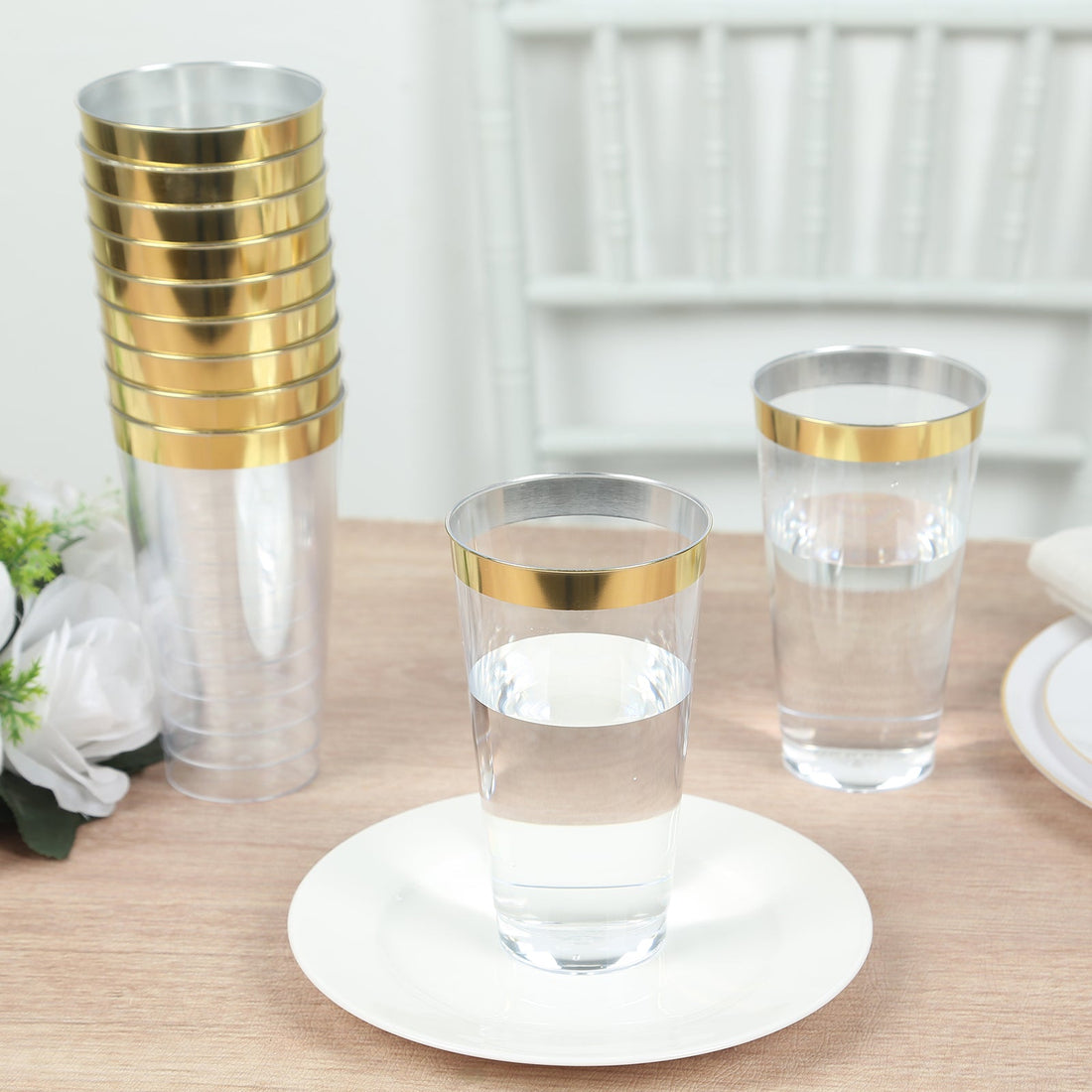 Clear plastic cups with gold rims on a wooden table.