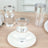 Clear plastic cups with silver rims on a wooden table setting.