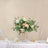 Elegant floral centerpiece in a glass vase with greenery and soft roses.