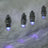 LED string lights with clear bulbs glowing in purple hues.
