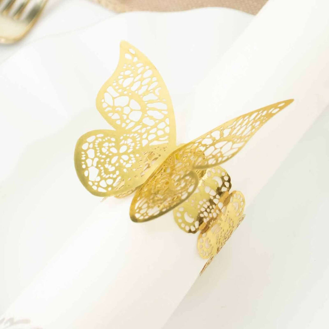 Gold butterfly napkin ring on a white table setting.