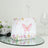 Decorative gift bag with butterfly and floral design on a reflective surface.