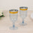 Two elegant blue champagne flutes with gold accents on a wooden table.