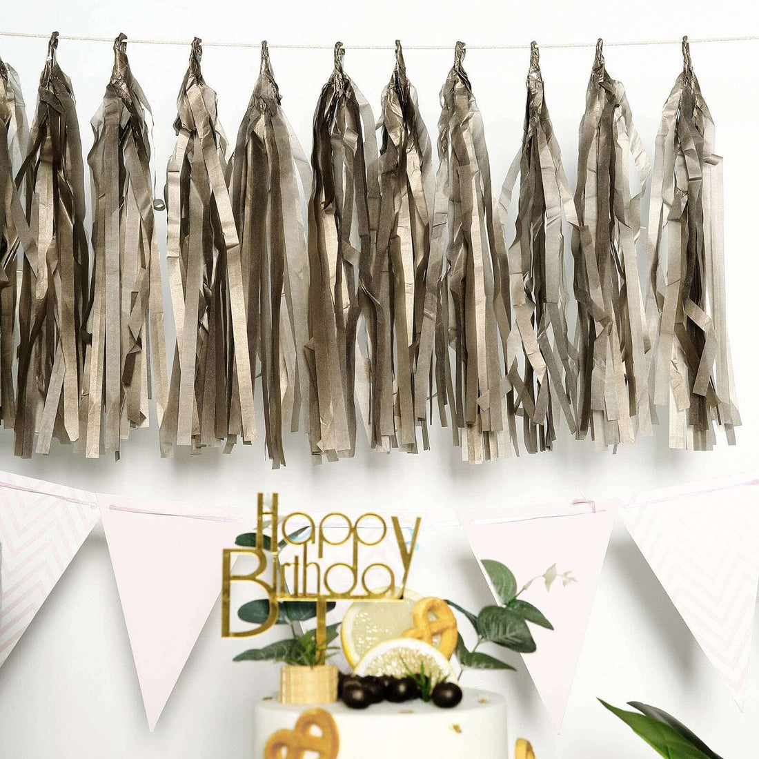 Birthday party decorations with tassels and cake centerpiece.
