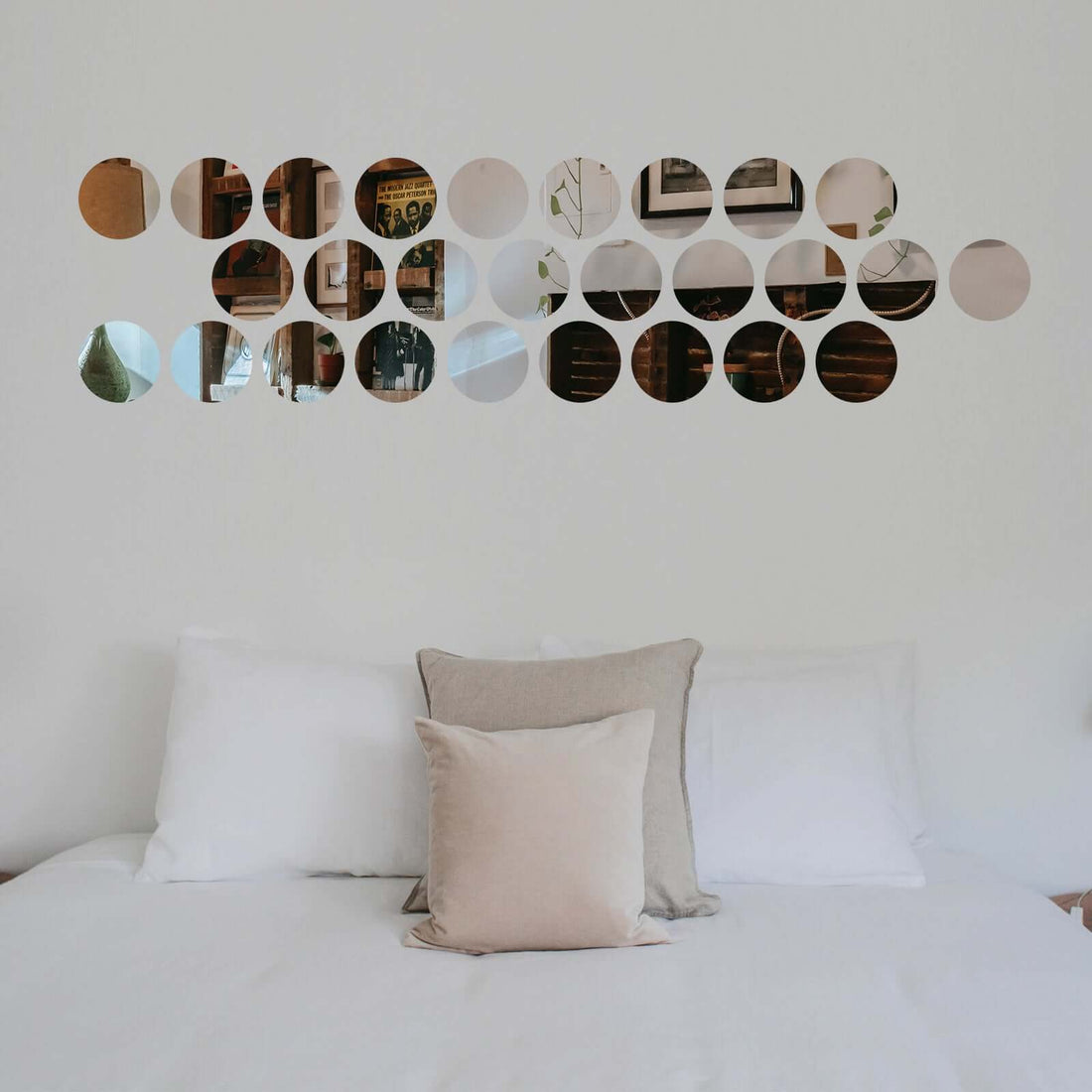 Decorative wall art featuring circular mirror cutouts above a bed.