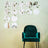 Green velvet chair in front of circular wall mirrors with plant designs.
