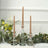 Glass candle holders with pink candles and greenery arrangement