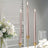 Elegant pink taper candles in gold holders with a floral centerpiece.