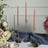 Elegant twisted candles in gold holders, surrounded by flowers and fabric.