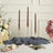 Set of three twisted brown candles in elegant gold holders.