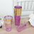 Set of purple plastic cups with gold rims on a wooden table.