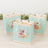 Colorful floral gift bags on a light wooden surface.