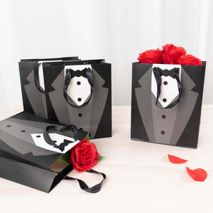 Tuxedo gift bags with black handles and red rose accents