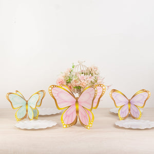 Colorful butterfly decorations on white plates with a floral centerpiece.