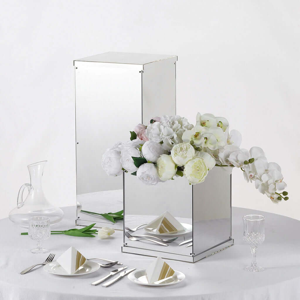 Mirrored cube pedestal centerpiece with white floral arrangement