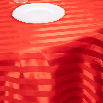 Red striped tablecloth draping over a table with a white plate.