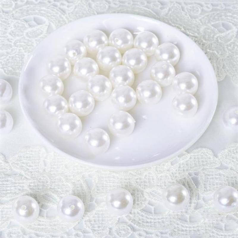 White decorative pearls arranged on a plate.