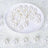 White decorative pearls arranged on a plate.