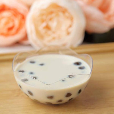 Tapioca pudding in a clear bowl with pearls, surrounded by soft pink roses.