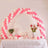 Pink and white balloon arch over a decorated table with flowers and treats. #whtbkgd