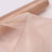 Sheer rose gold fabric draped elegantly with a roll in the background.
