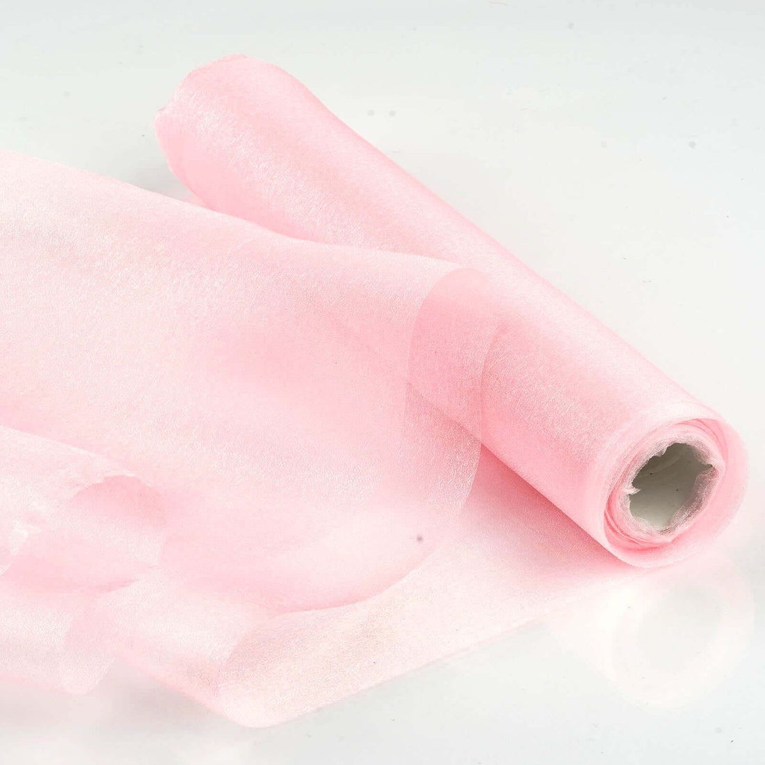 Pink tulle fabric roll on a white background