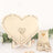 Wooden heart-shaped guest book display with small heart tokens.