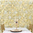 Elegant table setting with gold accents against a floral backdrop.
