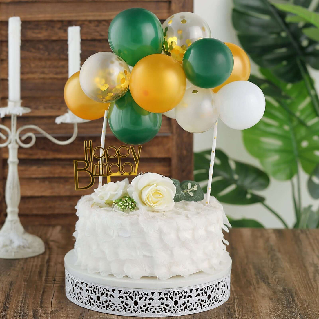 Birthday cake adorned with balloons and floral accents.