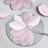 Pink decorative fabric leaves on a circular mirror surface.