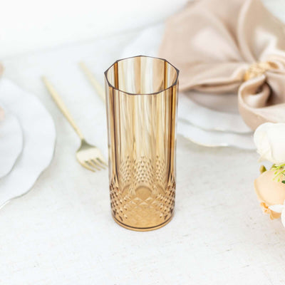 Amber glass vase with textured design on a neutral background.