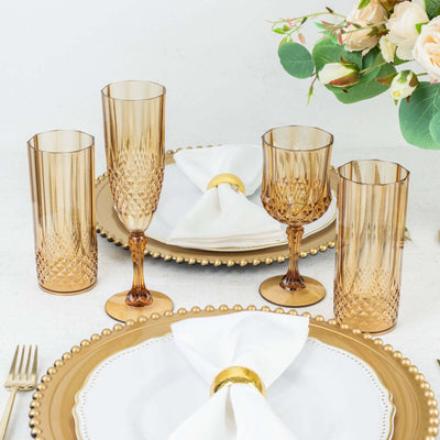 Elegant amber drinkware set with white napkin and gold-accented plates.