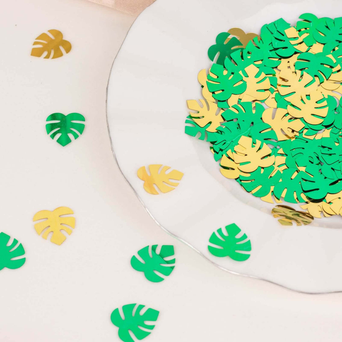Green and gold leaf-shaped confetti on a decorative plate.