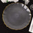 Elegant gray plate with a gold rim on a dark surface.