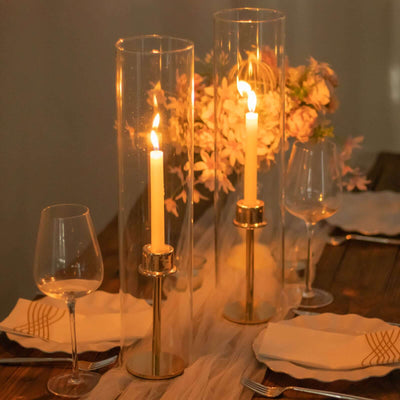Elegant candle holders with candles, set on a dining table with flowers.