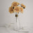 Glass vase with artificial yellow flowers and tableware