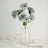 Clear glass vase with artificial gray flowers arranged elegantly.