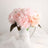 Pink peony flowers in a white pitcher vase.
