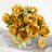 Golden rose bouquet with greenery in a silver vase.