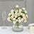 White rose bouquet in a clear vase with elegant table setting.