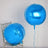Blue helium balloons on a silver chair against a textured background.