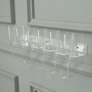 Clear champagne flute rack displaying six elegant glasses.
